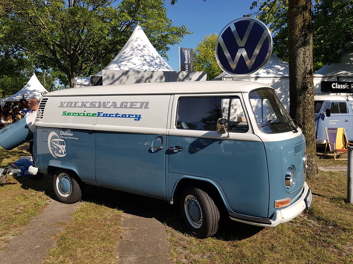 Blau-weisser VW T2 von Volkswagen Nutzfahrzeuge mit rundem VW Schild auf dem Dach