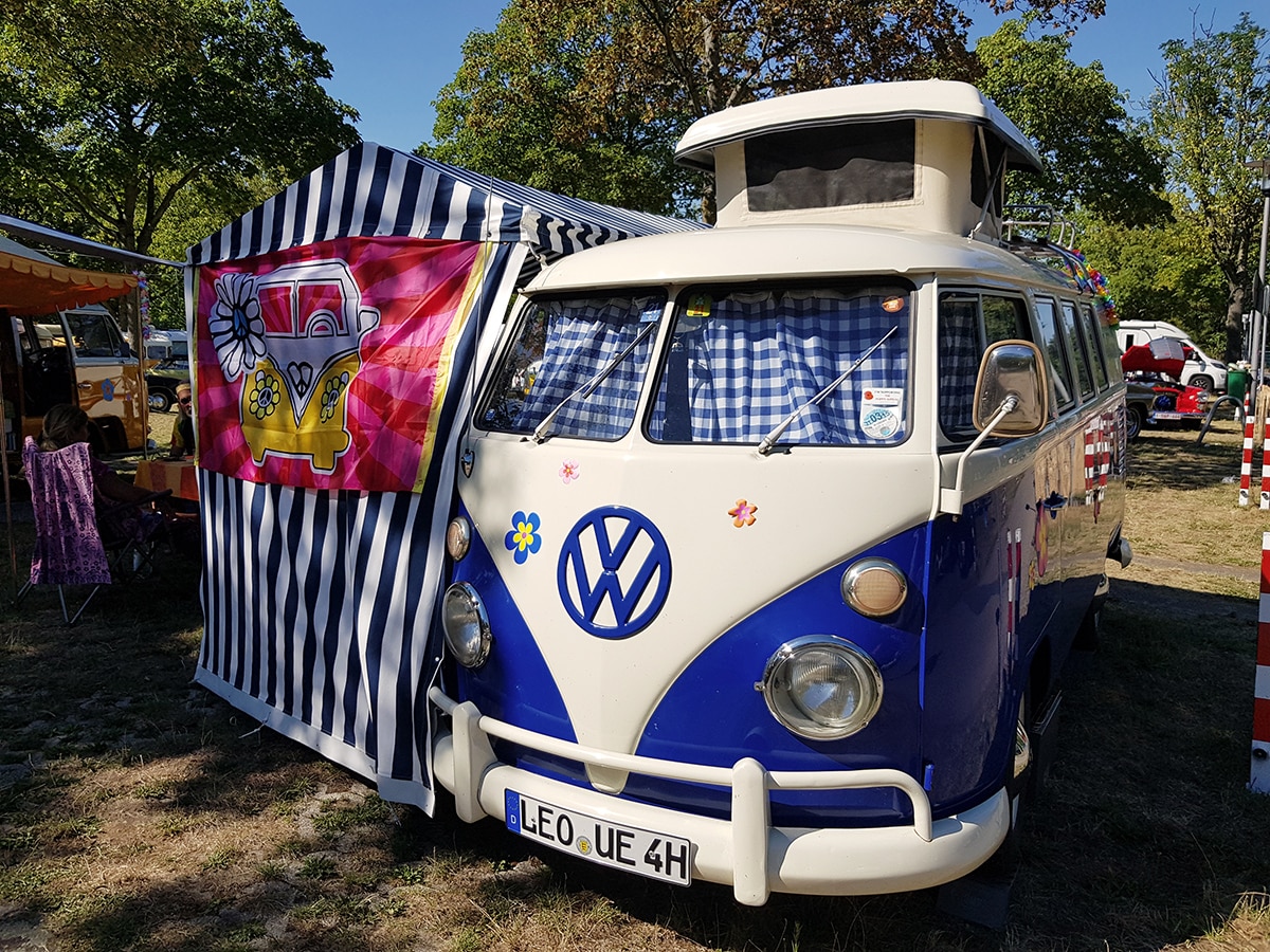 Blau-weißer VW T1 mit Pilzdach und blau-weiss gestreiftem Vorzelt