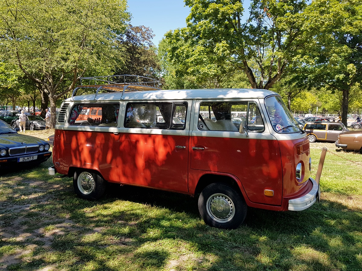 Rot-weisser VW Bus Oldtimer auf dem Parkgelände des Festivals