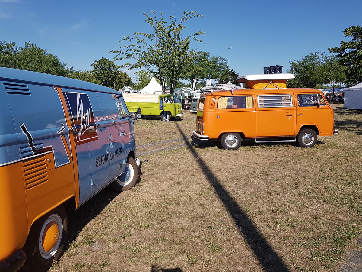 Blau-orangefarbener VW Bus Oldtimer und orangefarbener VW T2 Bulli mit Pilzdach