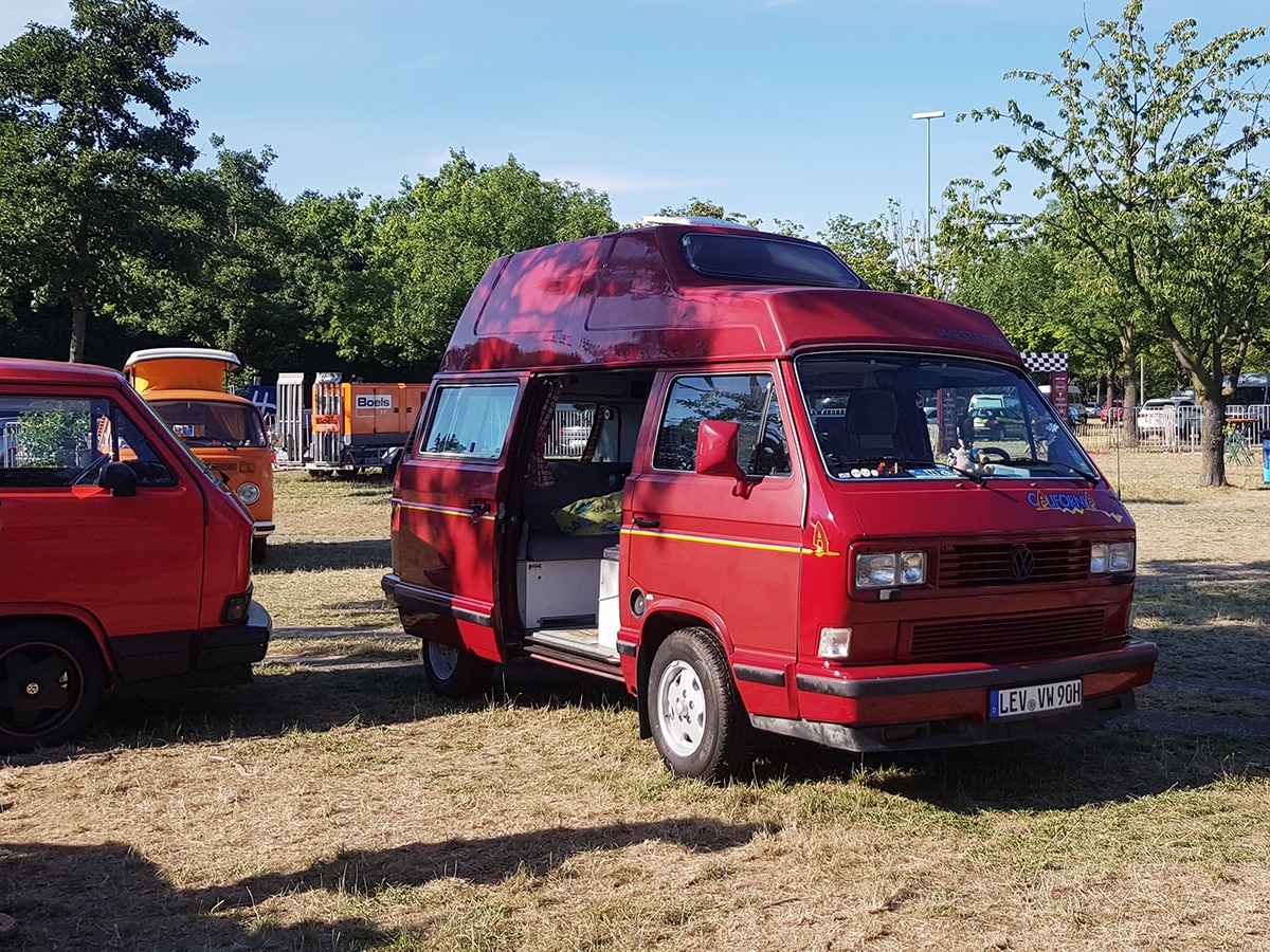 Roter VW T3 mit Hochdach in Wagenfarbe
