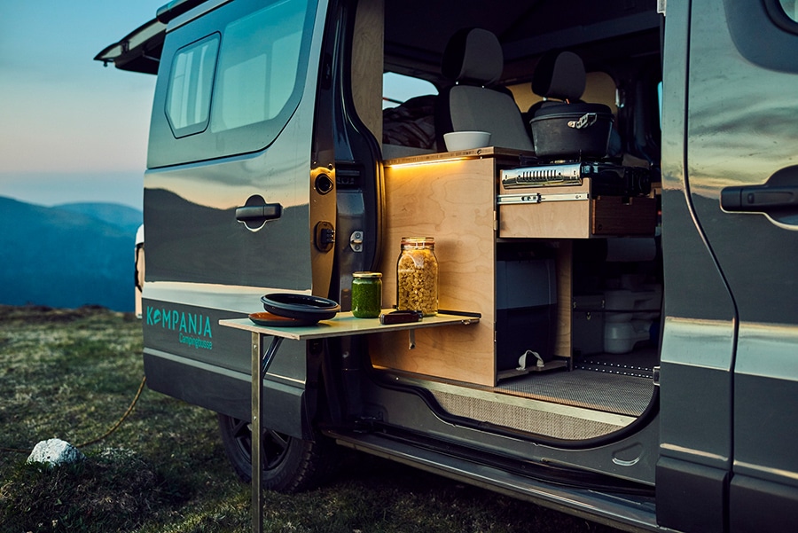 Die Küche befindet sich an der Schiebetür, der Tisch kann innen oder außen eingehängt werden.