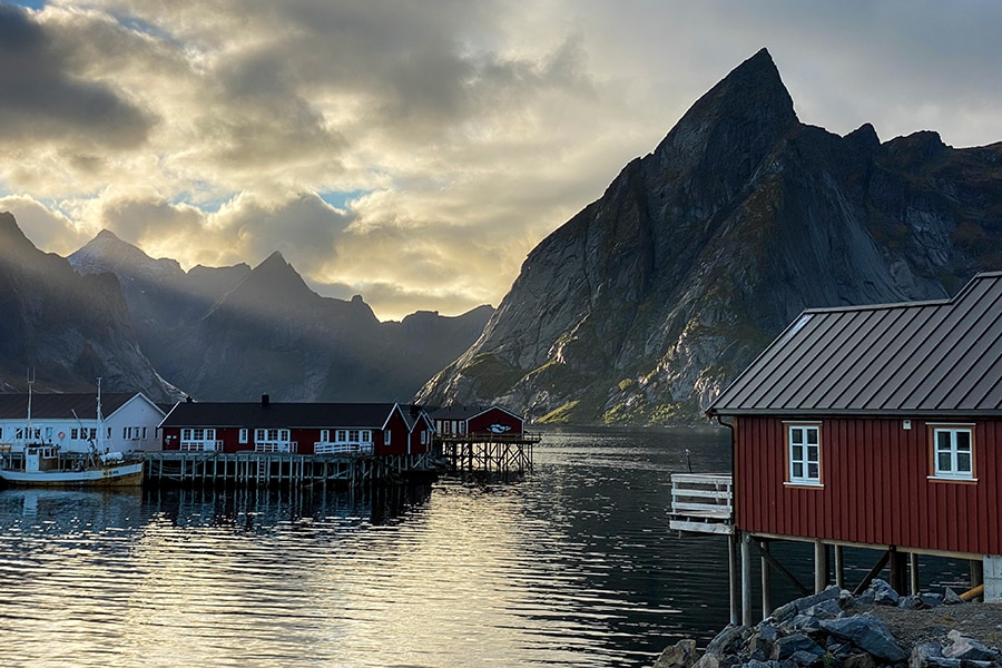 Rote Häuschen auf Pfählen am Ufer gebaut inmitten eines Fjords