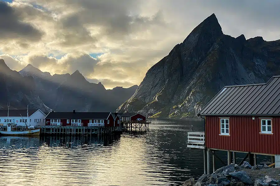 Rote Häuschen auf Pfählen am Ufer gebaut inmitten eines Fjords