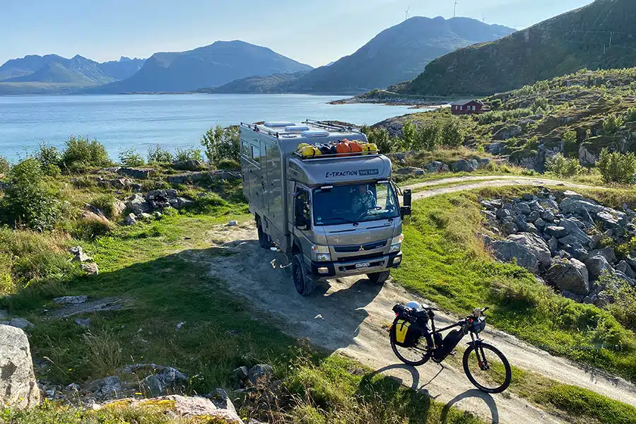 Overlander auf unbefestigter Straße entlang dem Meerufer durch zerklüftete, aber grüne Landschaft