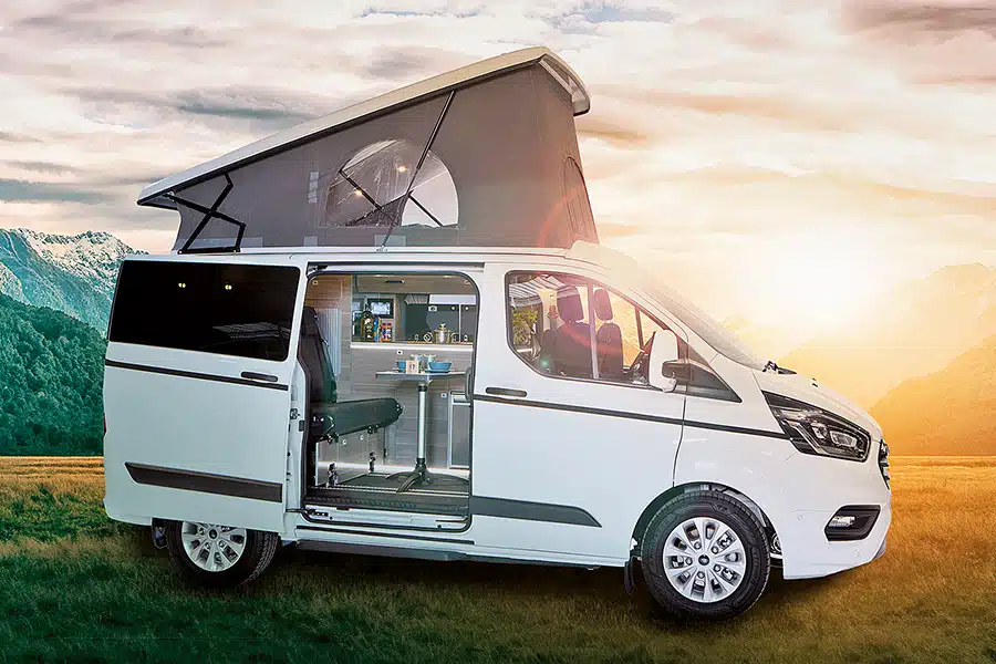 Weißer Campingbus MobiLTec Vialla in bergiger Landschaft bei Sonnenaufgang