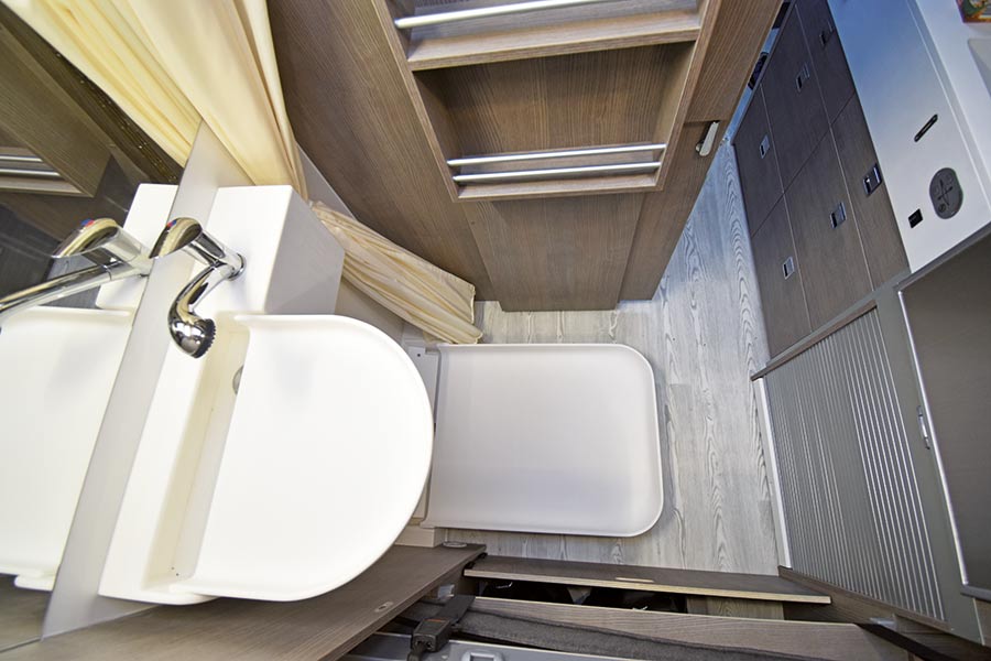 Halbrundes Waschbecken und eckige Duschwanne in der Nasszelle