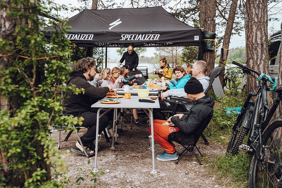 Eine Gruppe Menschen sitzt an einem großen Tisch in der Natur
