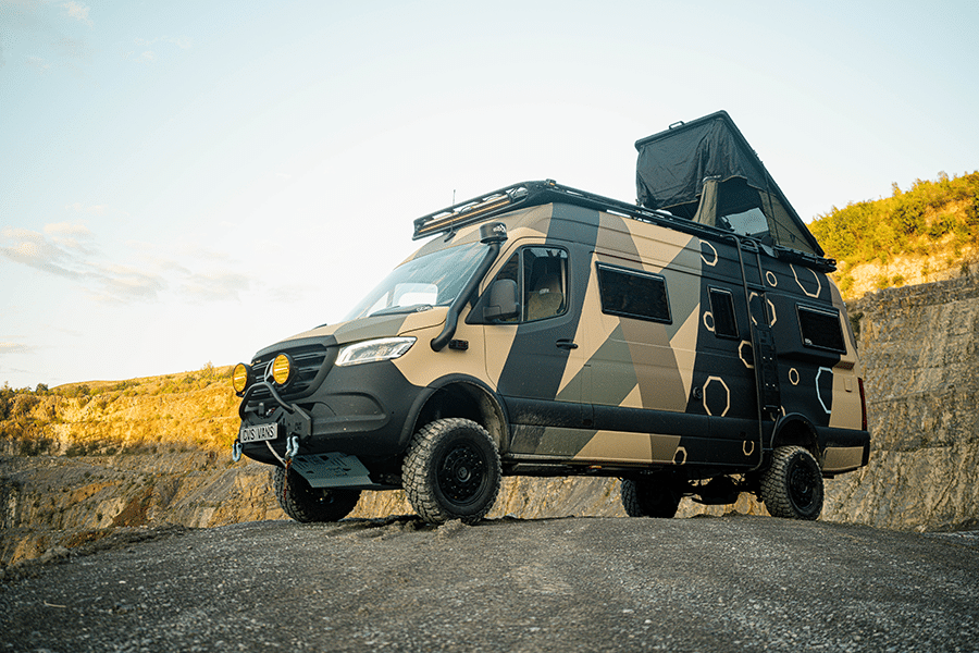 Offroad-Kastenwagen mit Camouflage-Lackierung im felsigen Gelände