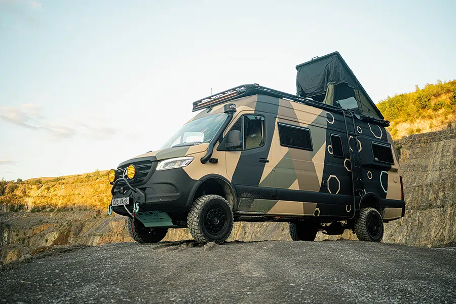 Offroad-Kastenwagen mit Camouflage-Lackierung im felsigen Gelände