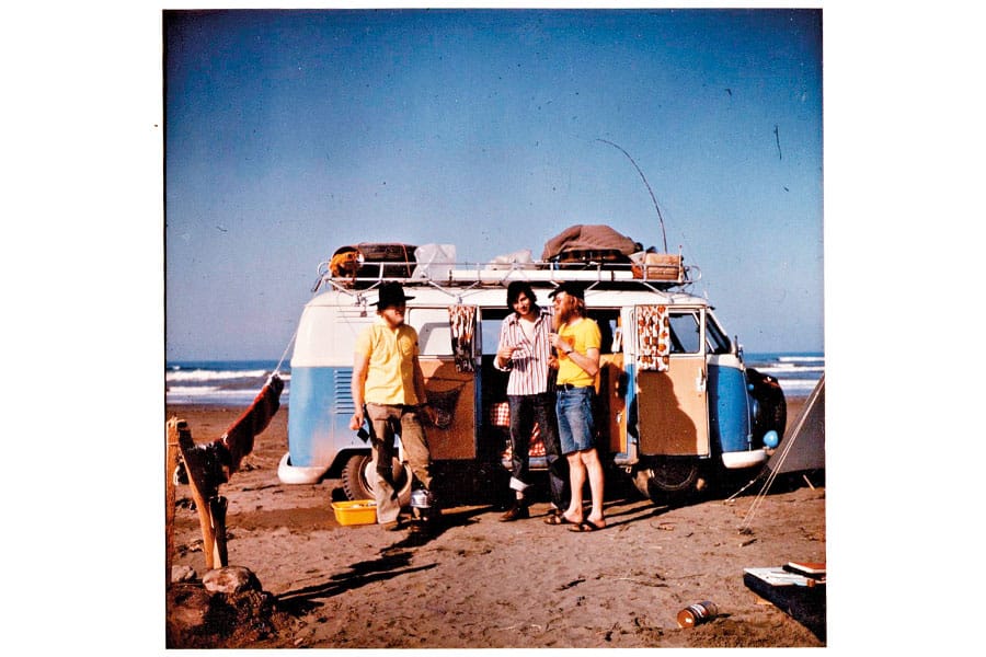 Drei Camper vor weiß-blauem VW Bulli auf dem Strand
