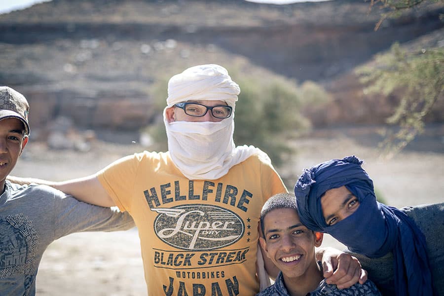 Mann mit weißem Turban und drei marokkanische Jugendliche posieren für ein Bild