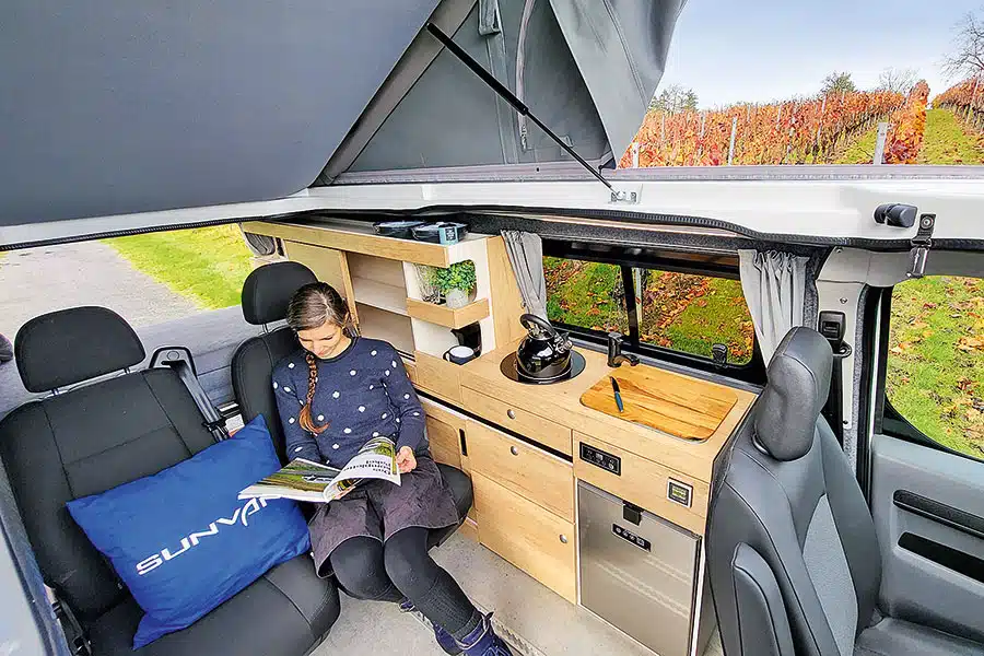 Frau sitzt auf hinterem Einzelsitz im Sunvan Campingbus