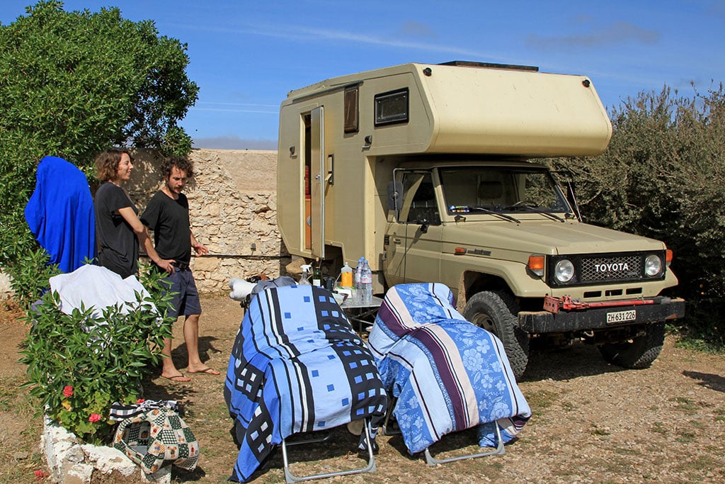 Ein Camper-Paar neben seinem Alkoven-Mobil