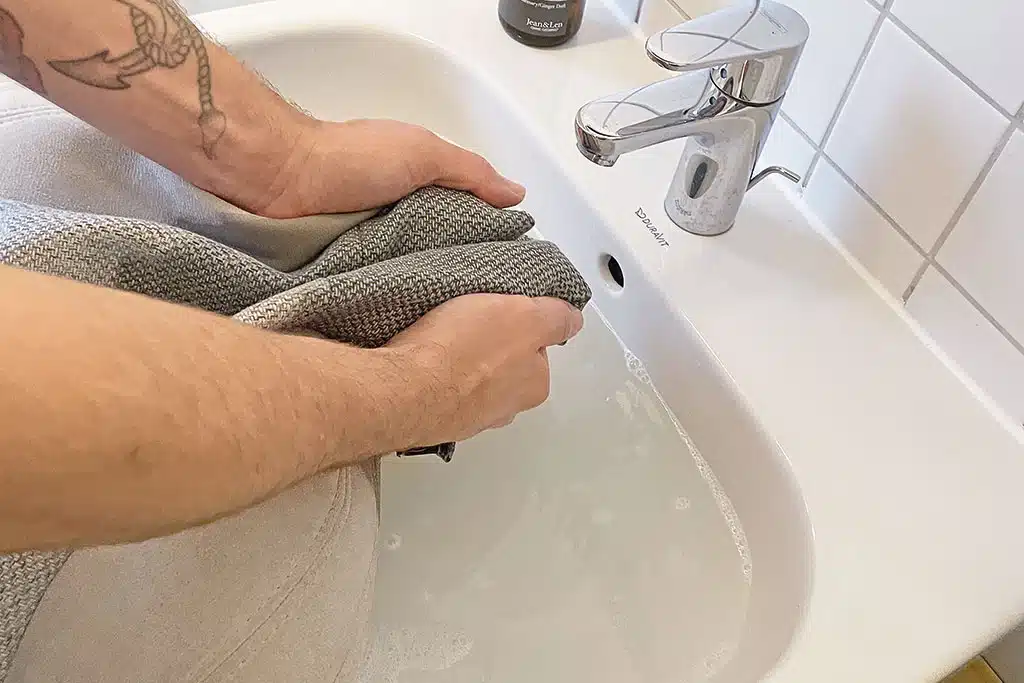 Handwäsche eines Sitzpolsters im Waschbecken
