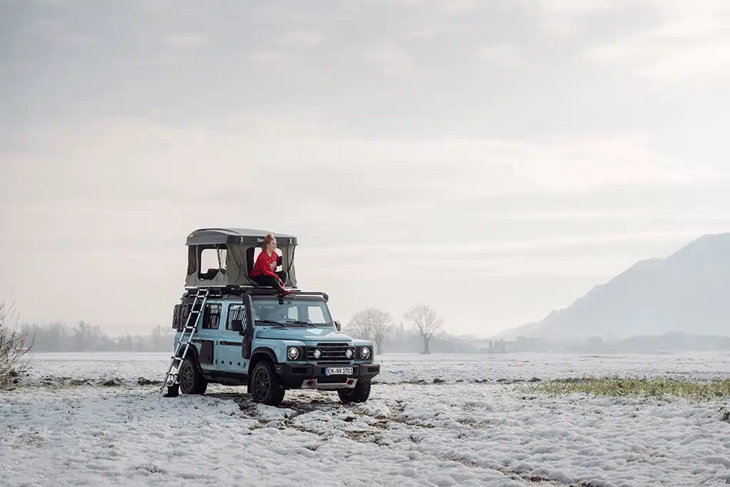 Reise-Zubehör für den Ineos Grenadier: weißer Grenadier Geländewagen mit Hartschalendachzelt in Winterlandschaft