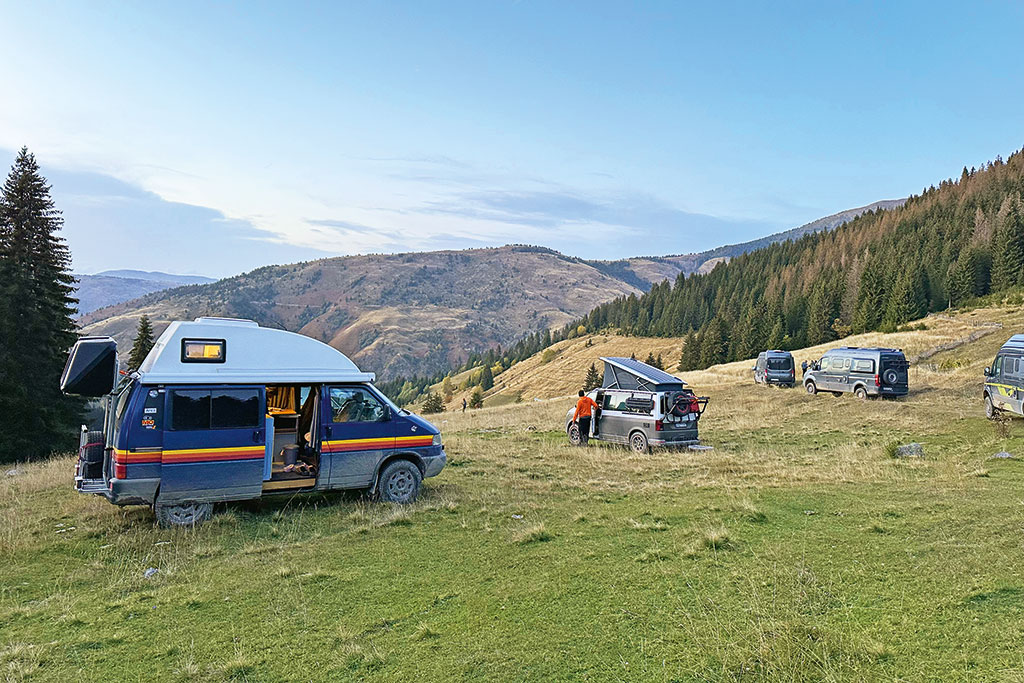 Einige Campingbusse auf einer Hochebene im Gebirge