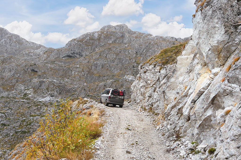 Vw-Bus auf schmalem, in ein Felsmassiv gehauenen Weg