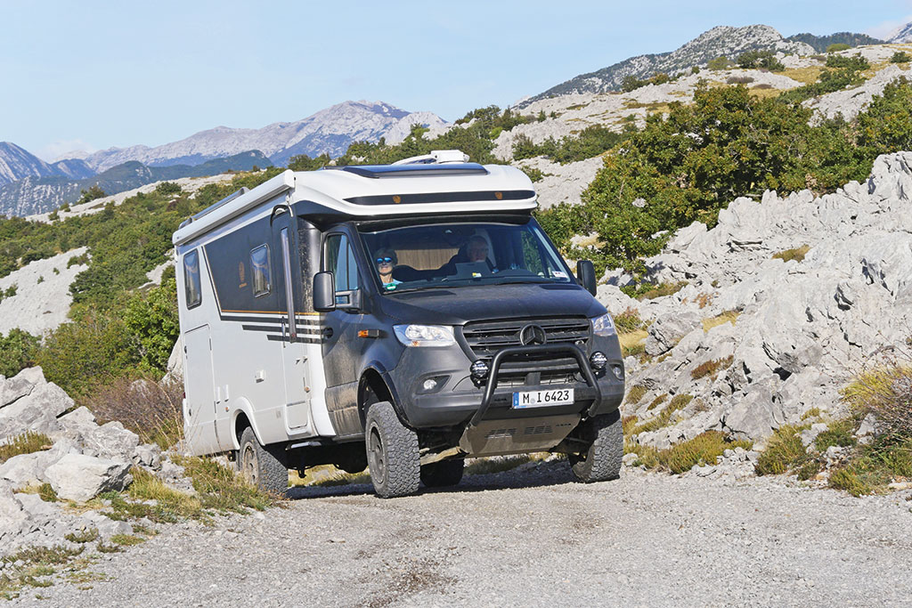 Mercedes-Pritsche mit Wohnkabine auf Schotterpiste