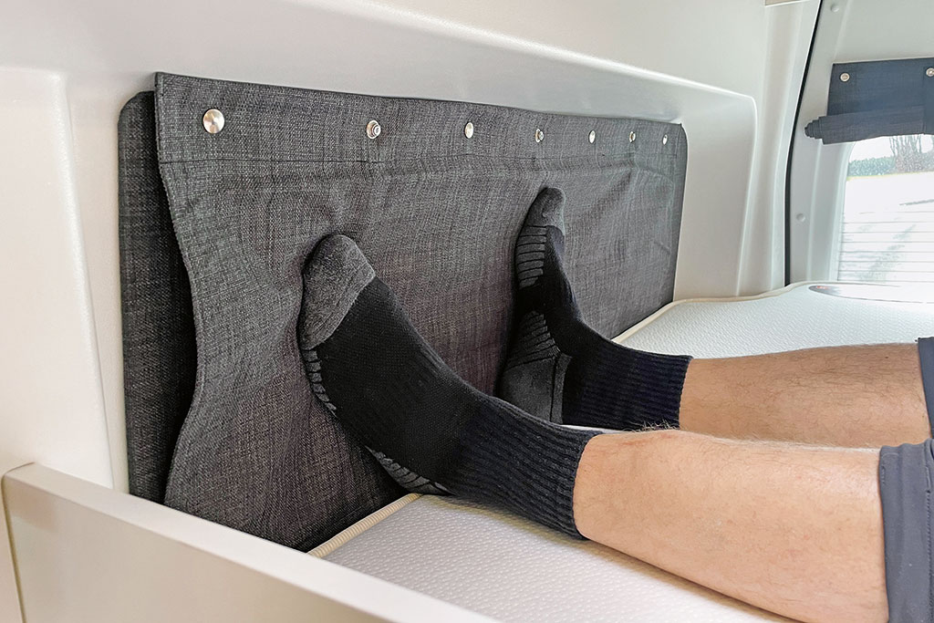 An die Seitenwand anstoßende Füße im Heckbett