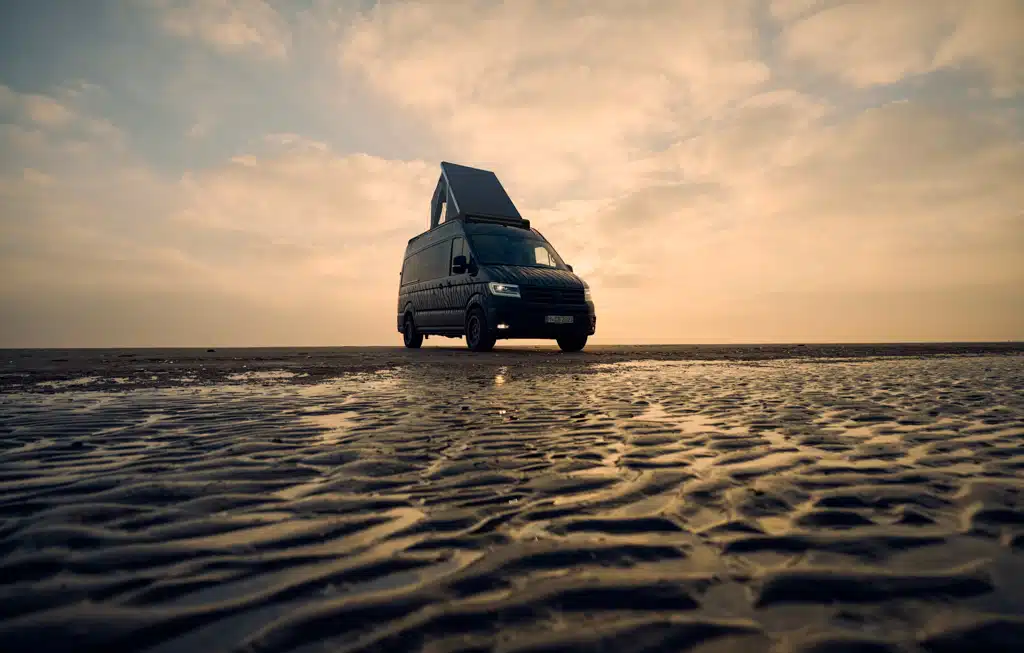 Kastenwagen mit Aufstelldach am Meer in Abenddämmerung