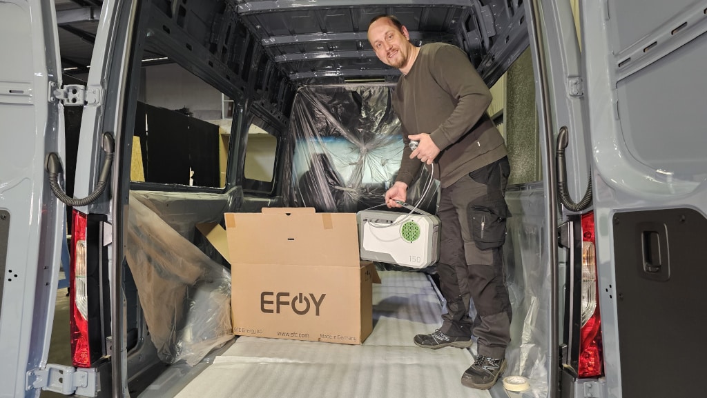 Mann im Van packt eine EFOY Brennstoffzelle aus.