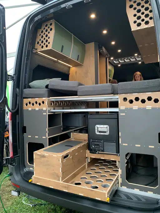 Heckansicht eines Campervans, der mit Leichtbau-Möbeln mit vielen runden Ausfräsungen ausgebaut wurde