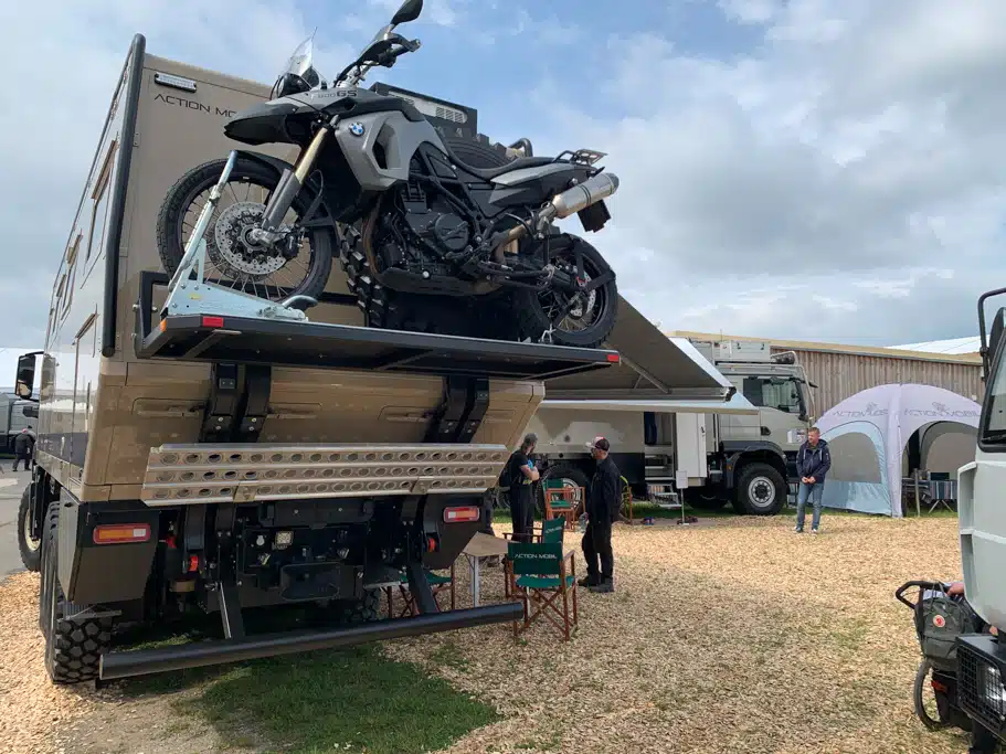 Ein Motorrad auf einem Heckträger an einem Expeditionsmobil