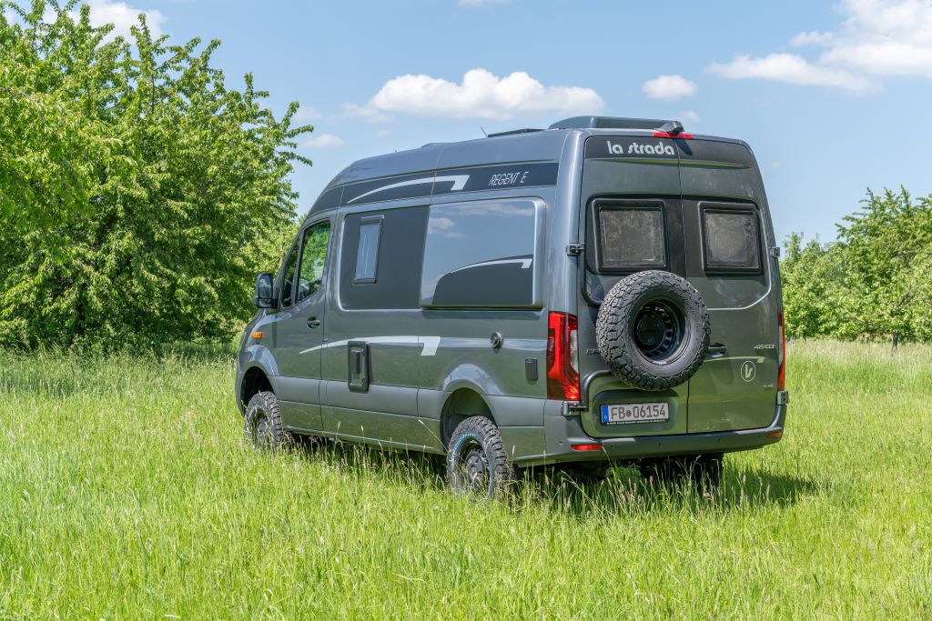 Seiten-/Heckansicht grauer Kastenwagen mit am Heck befestigtem Reserverad
