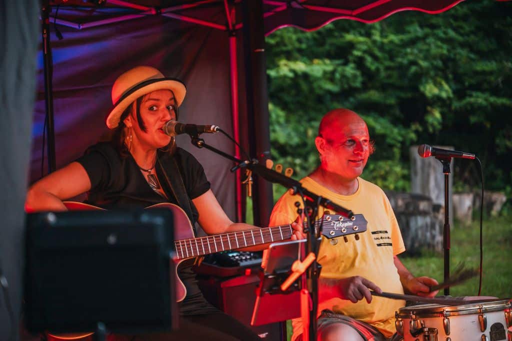 Eine Frau und ein Mann auf der Bühne, sie singt und spielt Gitarre, er spielt Schlagzeug