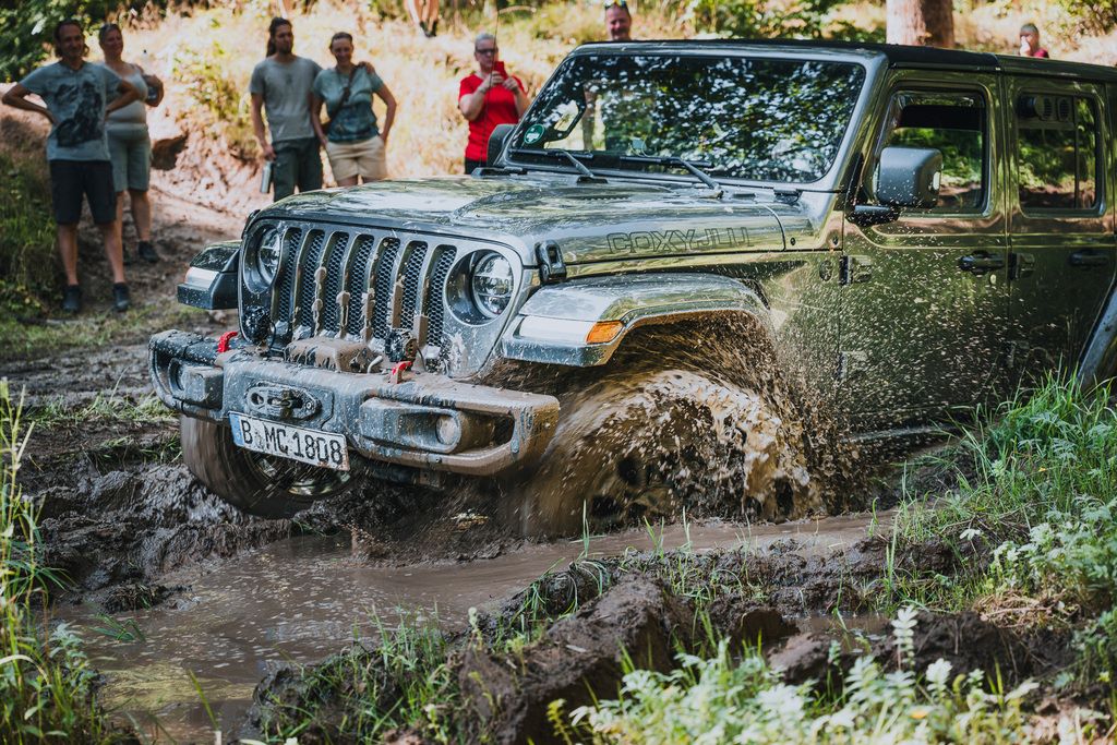 Ein Landrover fährt durch ein tiefes Schlammloch