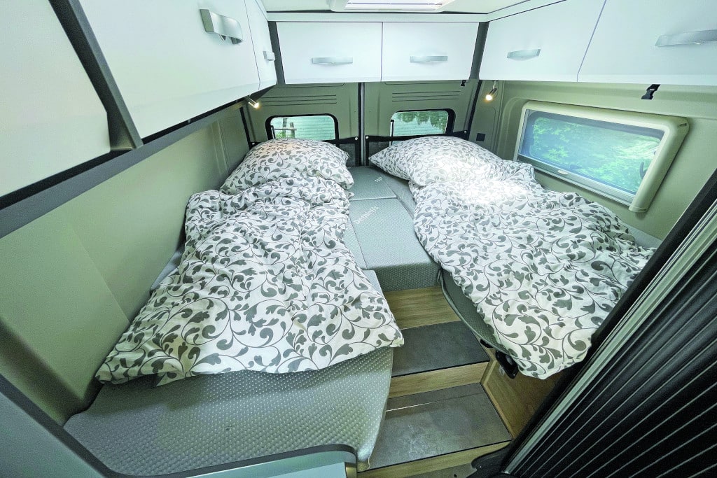 Zwei Einzelbetten mit treppenförmigem Zugang in der Mitte