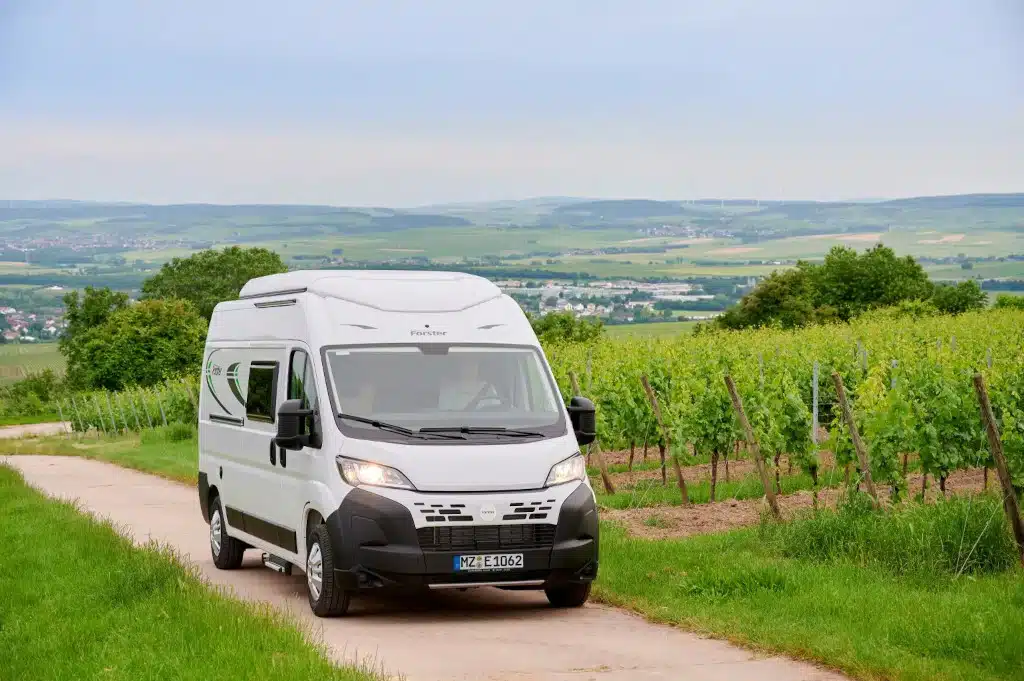 Campervan Forster Flip von außen auf Feldweg mit Aussicht
