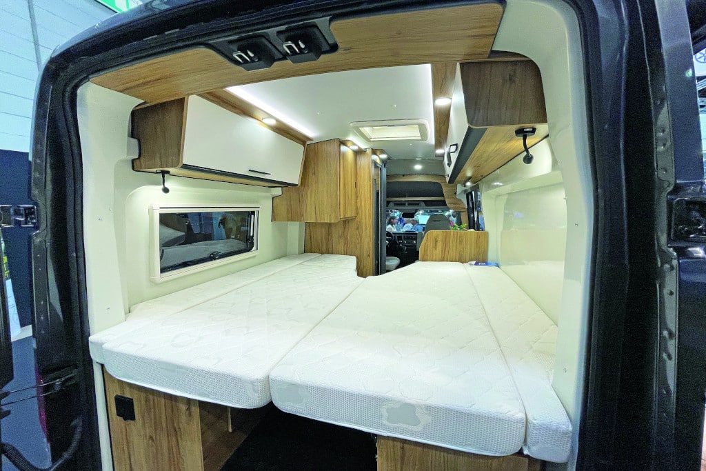 Blick durch die Hecktüre auf ebene Liegefläche und deckenhohe Dusche hinter dem Fahrersitz