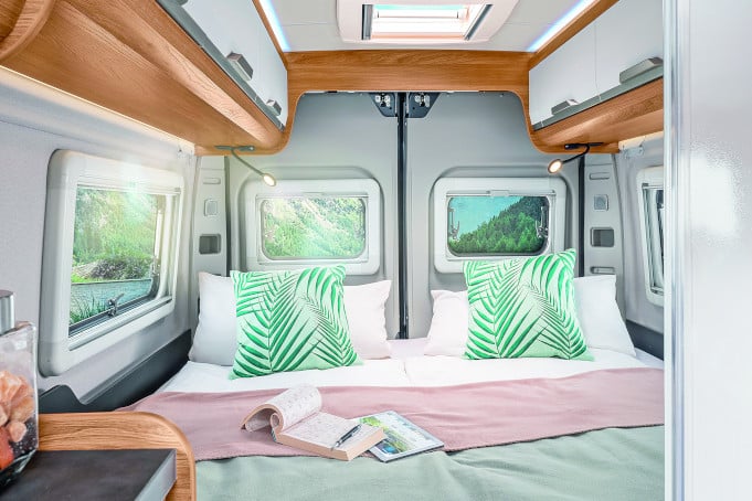 Blcik nach hinten auf durchgehendes Doppelbett mit dekorativen Kissen