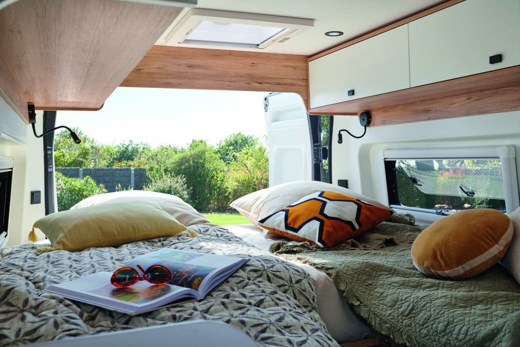 Zwei Längsbetten mit passgenauer Matratze im Schulterbereich vor geöffneter Hecktüre