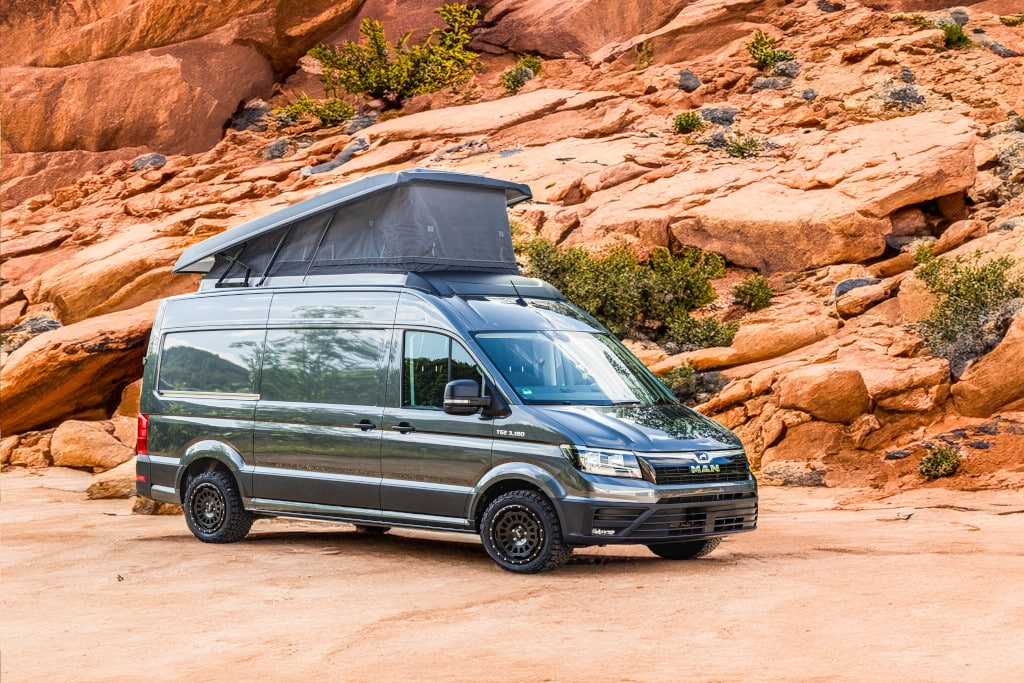 Kastenwagen mit offenem Aufstelldach in karger Felslandschaft