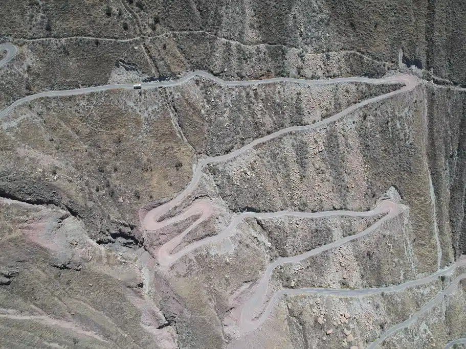 Luftaufnahme einer kargen Landschaft mit Serpentinenstraßen