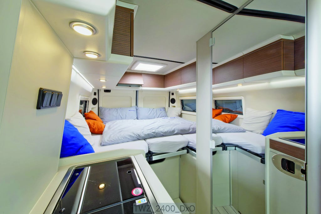 Blick zwischen Küchenblock und Spiegelschrank auf die Längsbetten