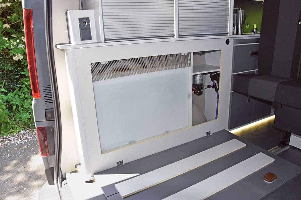 Wasserbehälter in einem seitlichen Fach im Campingbus