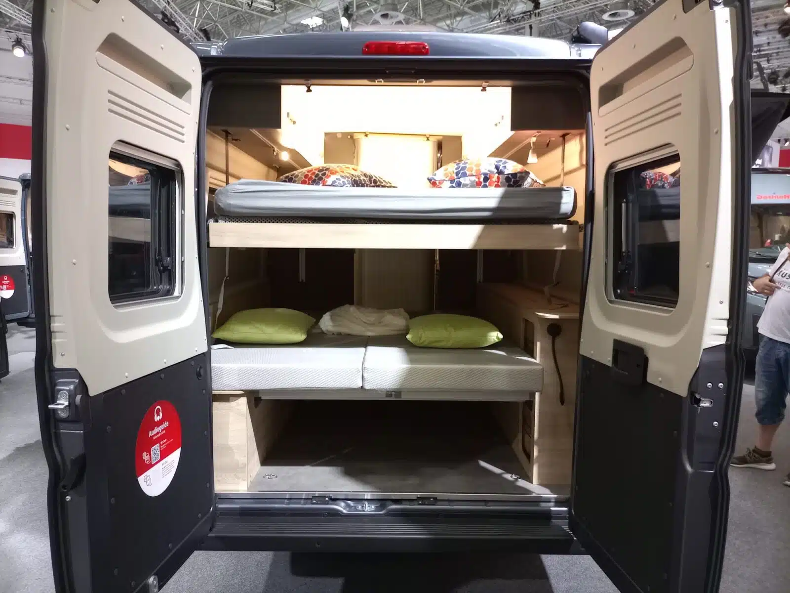 Heckansicht eines Campervans in einer Messehalle bei geöffneten Hecktüren
