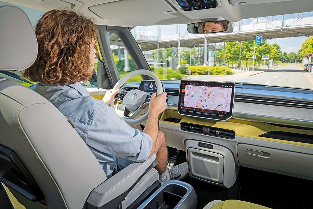 Mann am Steuer des ID. Buzz mit gelben Designelementen im Fahrerhaus