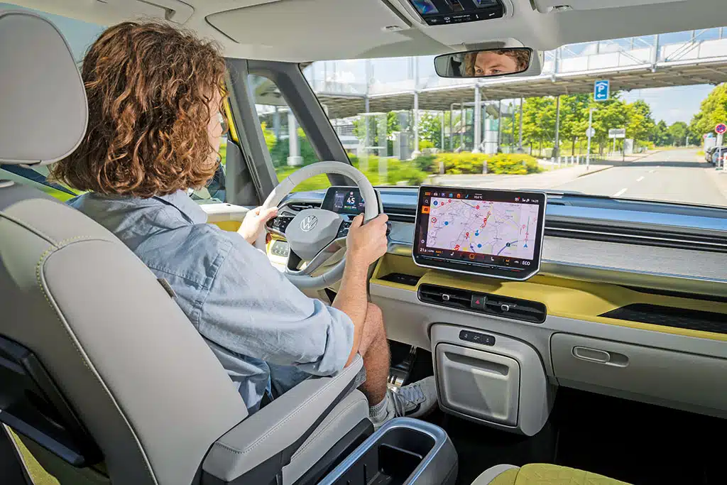 Mann am Steuer des ID. Buzz mit gelben Designelementen im Fahrerhaus