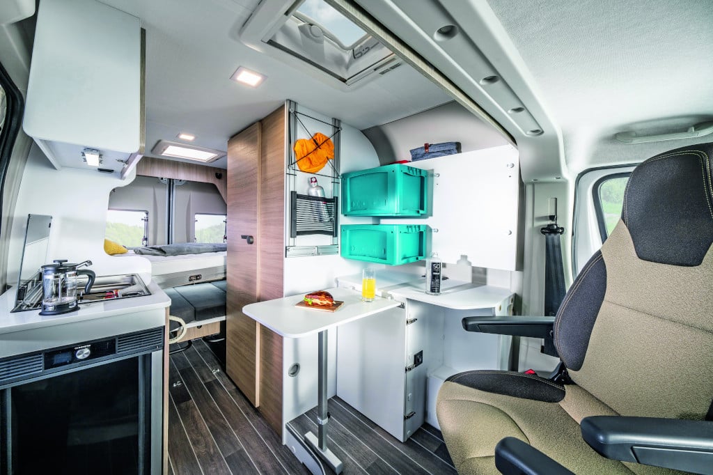 Blick von vorne auf Sitzbereich mit variablen Elementen bei Tisch und Schrank