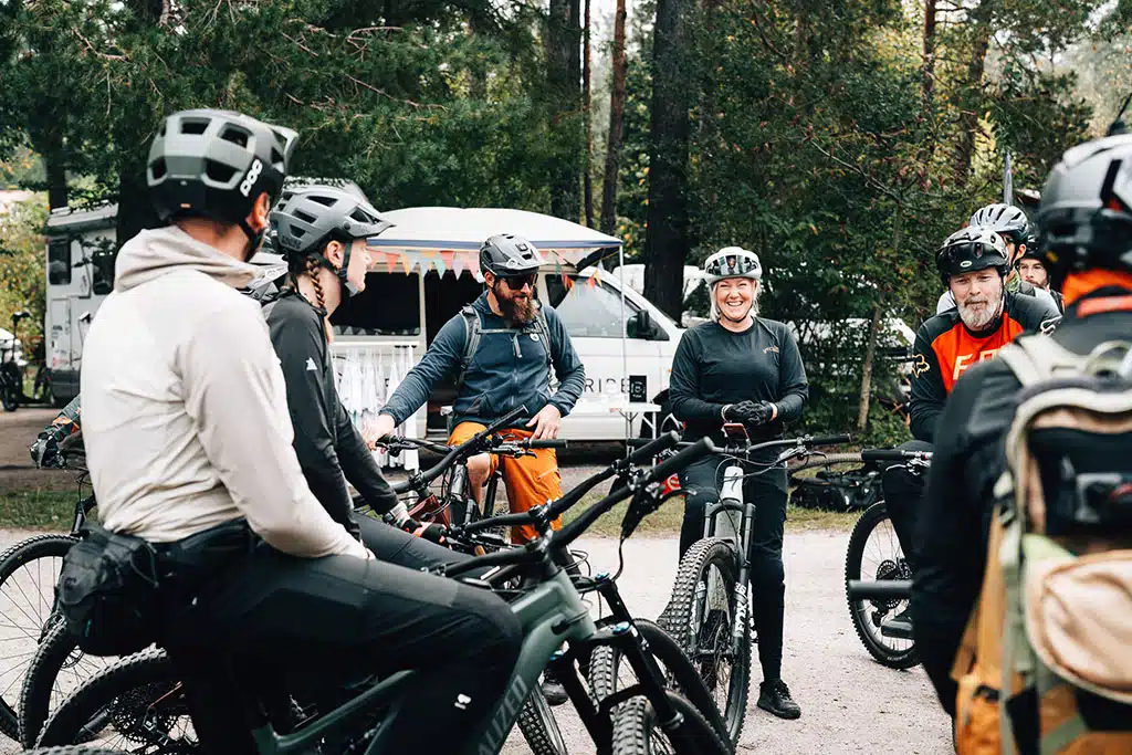 Mehrere Mountainbiker und Mountainbikerinnen stehen zusammen auf dem Veranstaltungsgelände