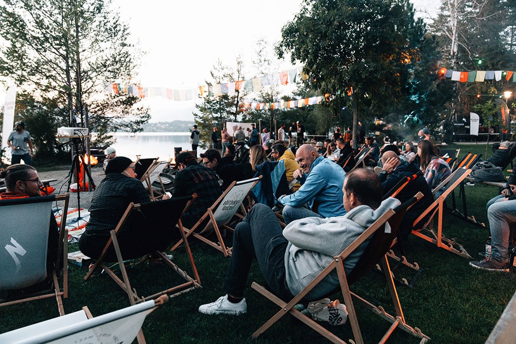 Eine Gruppe Menschen auf Liegestühlen am See