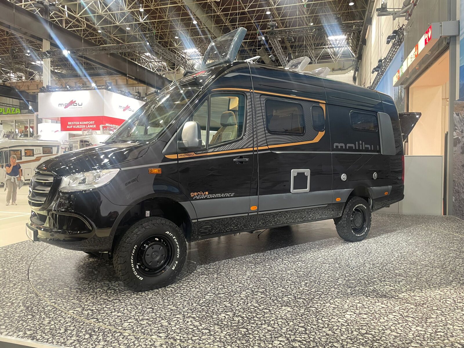 Schwarzer Campervan in einer Messehalle