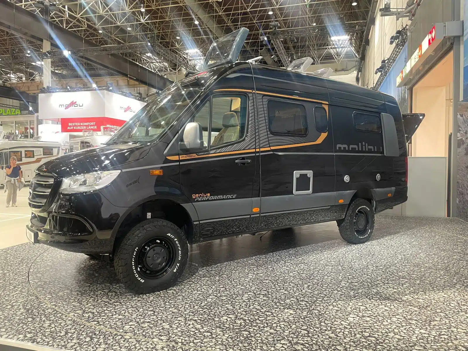 Schwarzer Campervan in einer Messehalle
