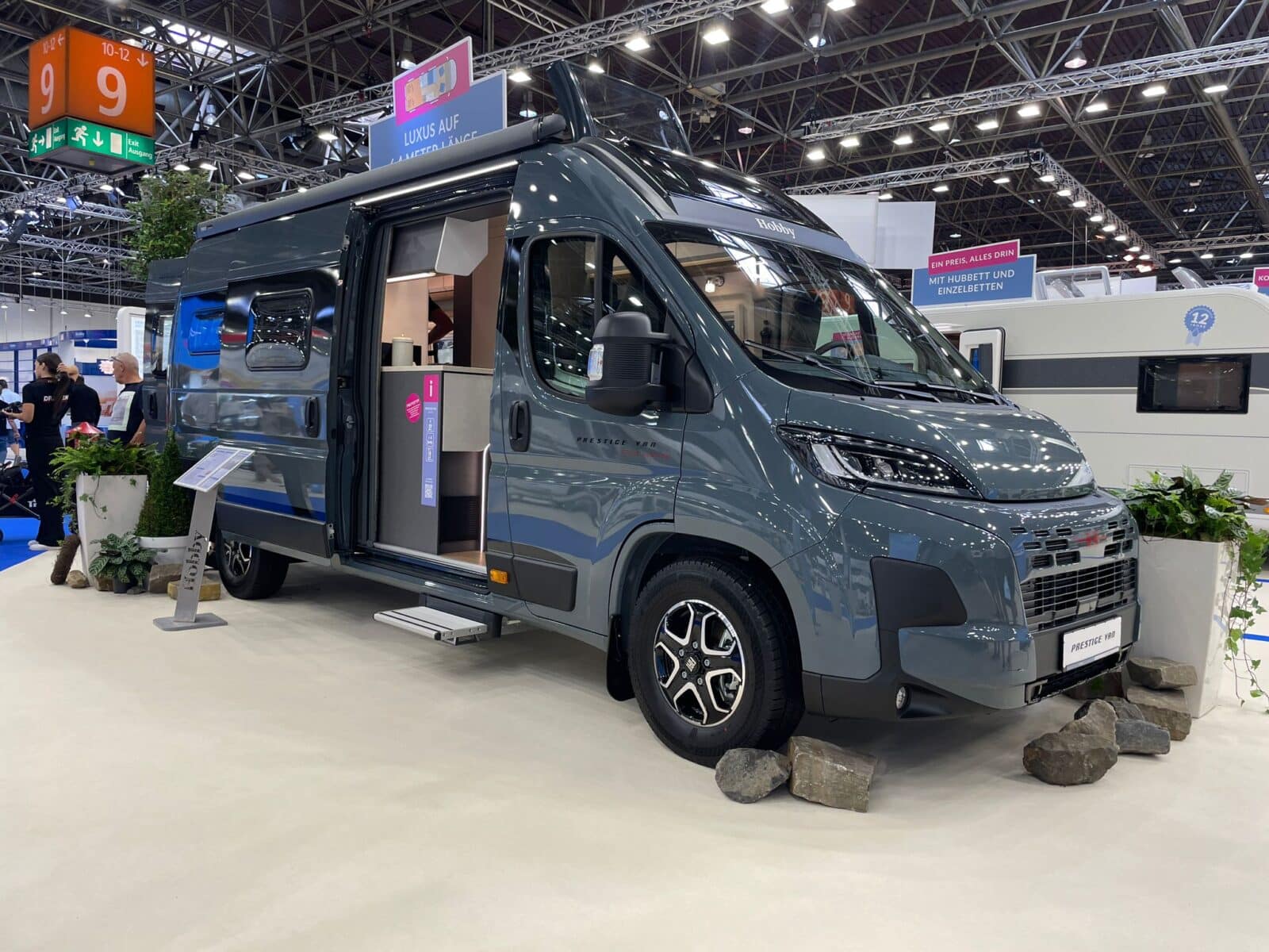 Grauer Campervan in einer Messehalle