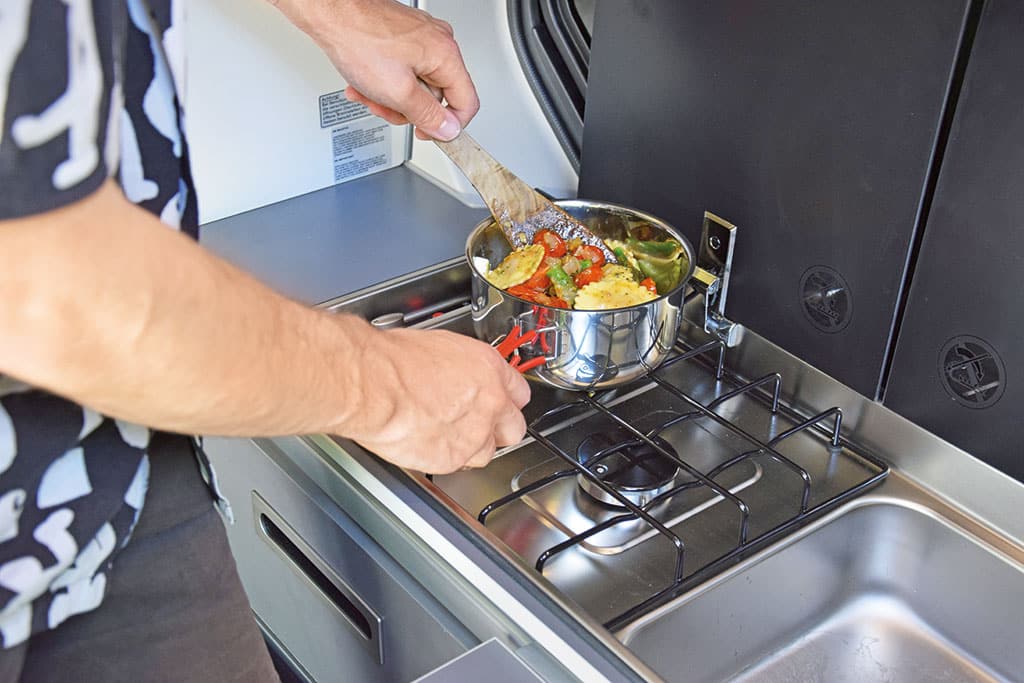 Kochen auf einer Gas-Flamme im Campingbus